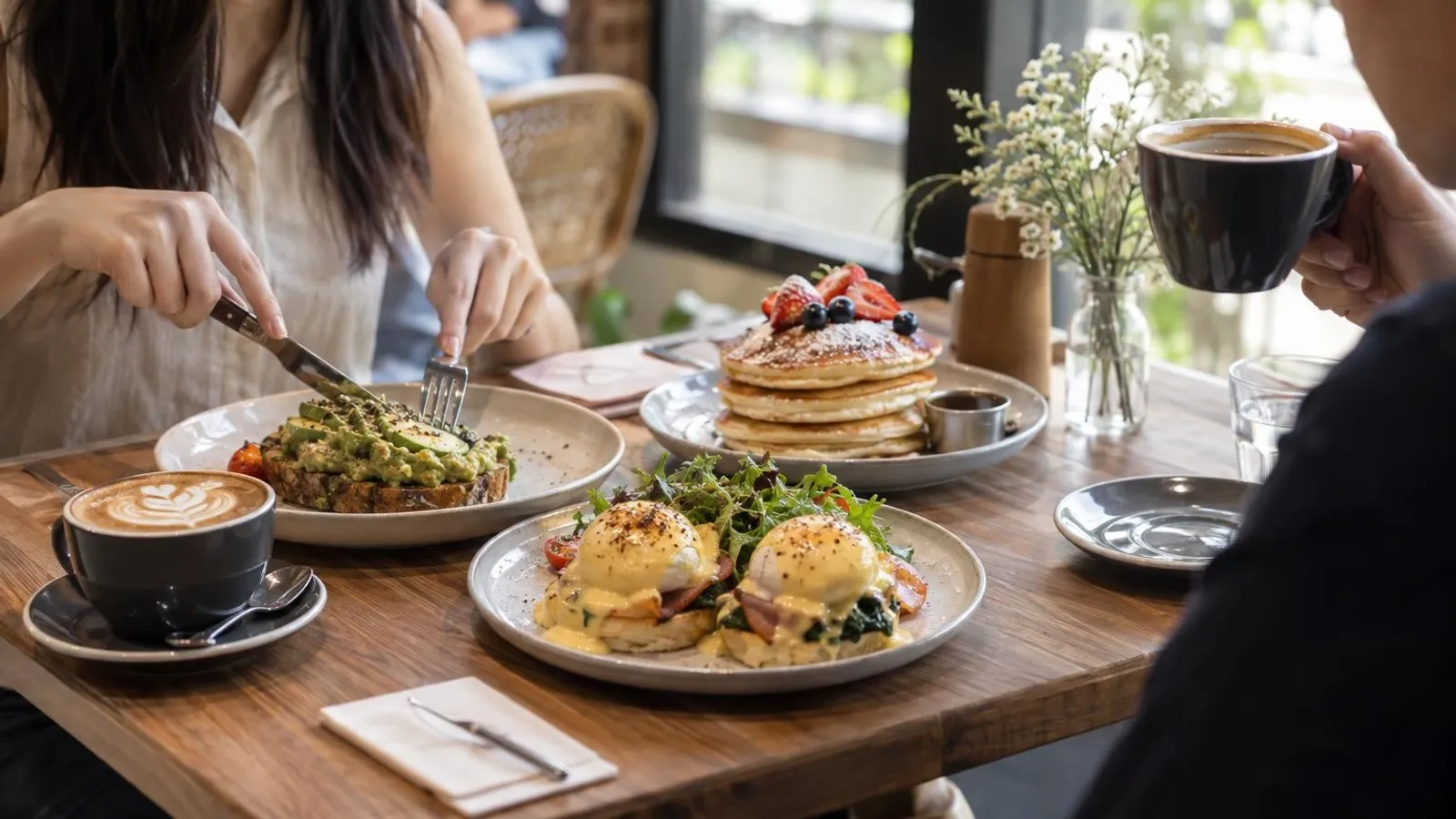 A brunch spread of eggs benedict, avocado toast and pancakes in Singapore