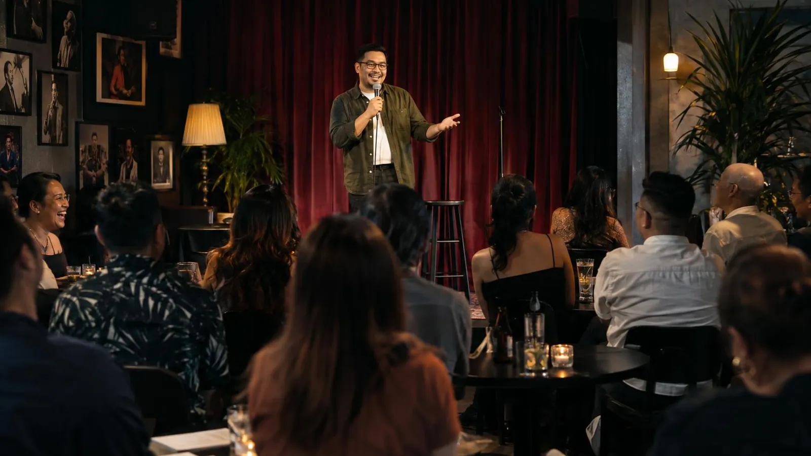 An audience laughing while a comedian performs on a small stage