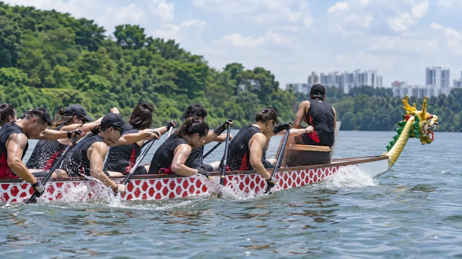 A dragon boat team paddling in unison across a Singapore reservoir