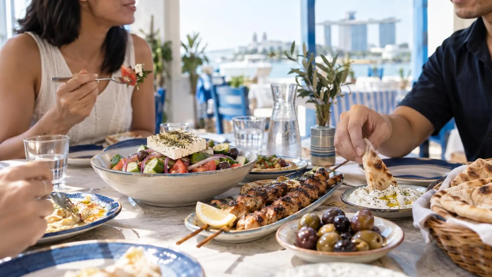 A Greek mezze spread with souvlaki, Greek salad, tzatziki and pita at a Singapore taverna